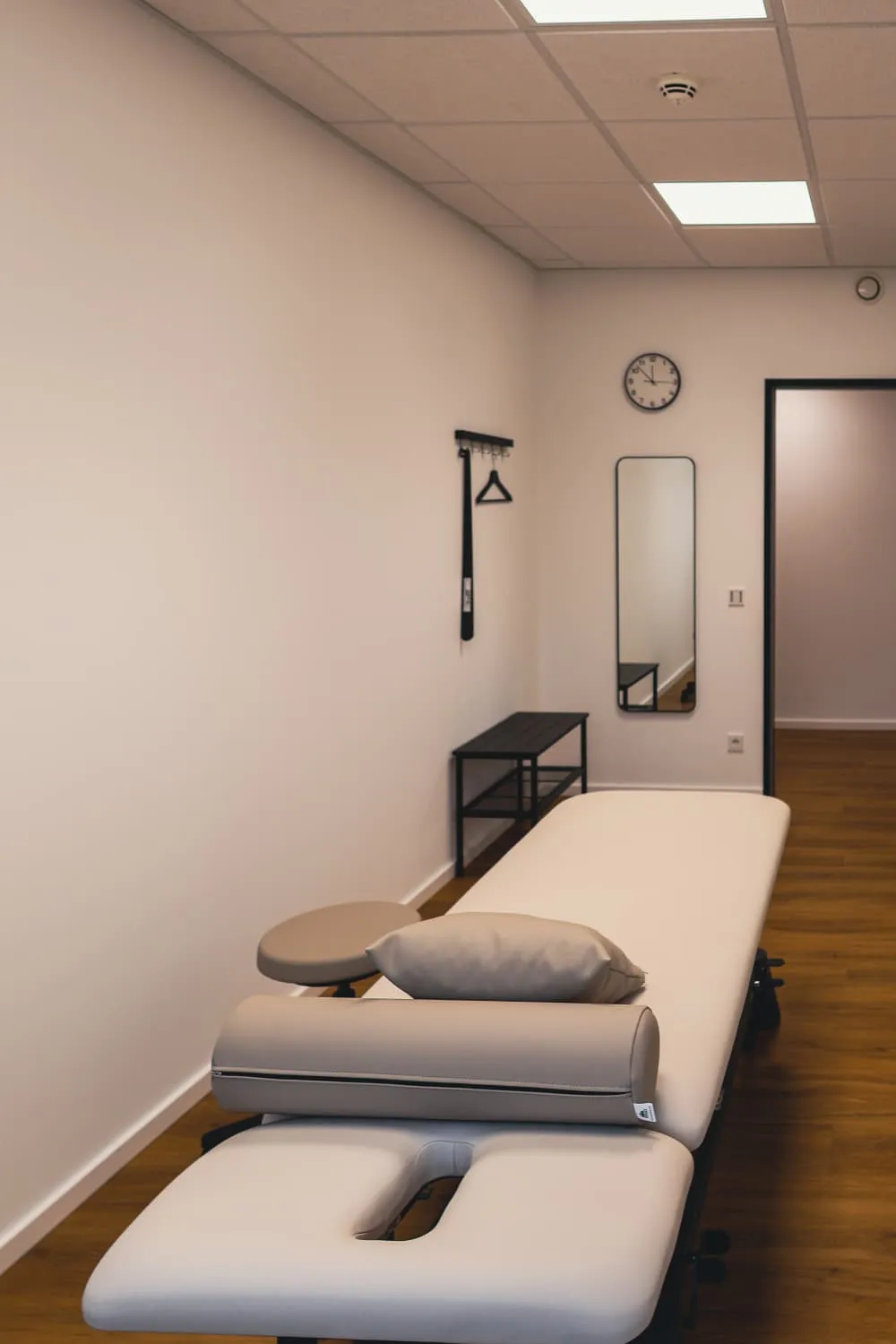 Therapieliege mit Lagerungskissen, Spiegel und Uhr in der AMILU Ergotherapie in Oberursel